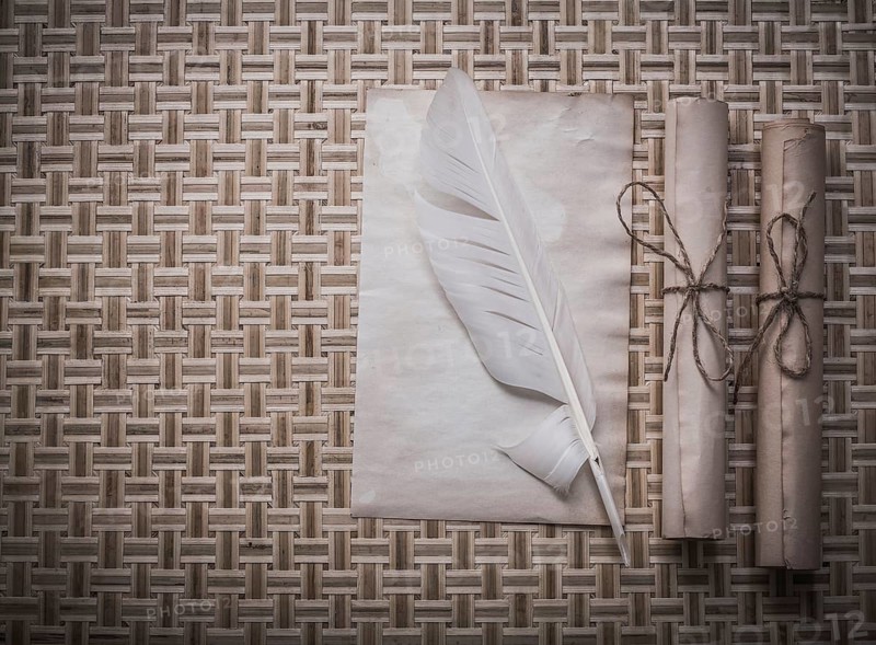 Rolls of vintage paper clean sheet quill on wicker mat