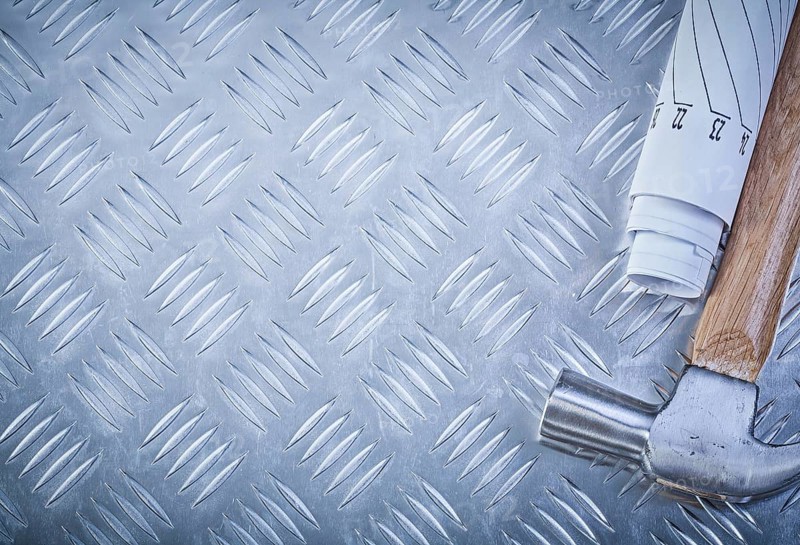 Claw hammer blueprints on grooved metal sheet copy space construction concept