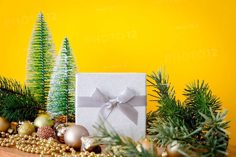 A Christmas decoration glass balls with fir trees on yellow background