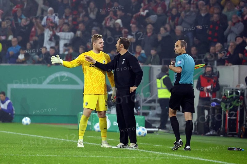 During a stoppage in play, head coach / coach Julian Schuster (SC Freiburg) gives instructions to goalkeeper Florian Müller (SC Freiburg) during the match for the DFB Cup 2024-25, 2nd round: SC Freiburg vs Hamburger SV, Freiburg im Breisgau, Germany / Germany