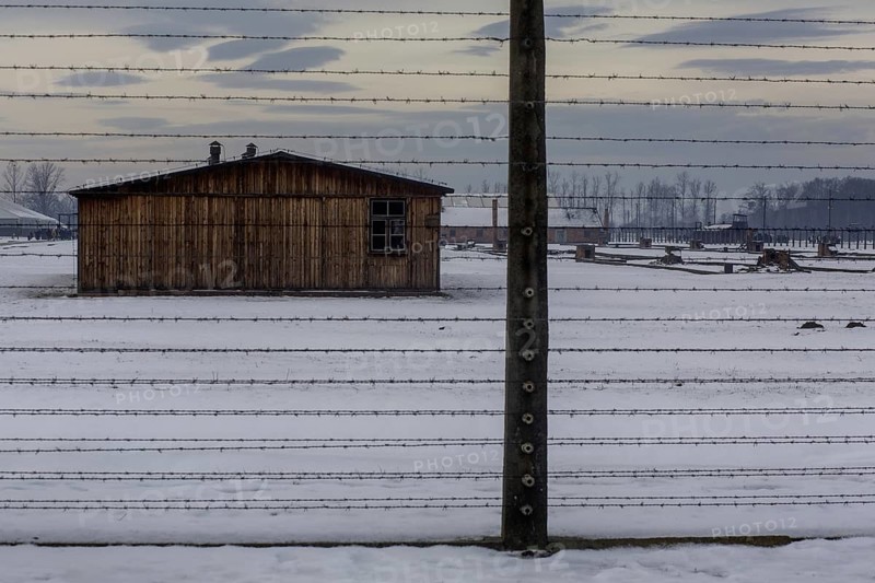 A view of the outside fence at the camp in Birkenau with winter snow on the ground. Birkenau, Poland