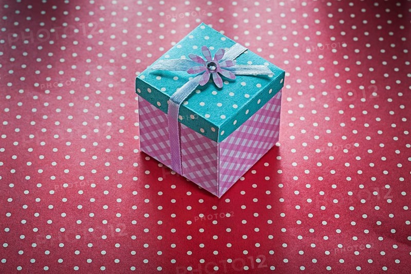 Present box on red polka-dot table cloth celebrations concept