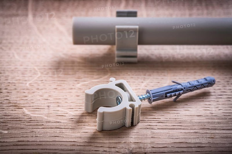 Close Up Pipe With Clips And Polypropylene Fixator On Wooden Board
