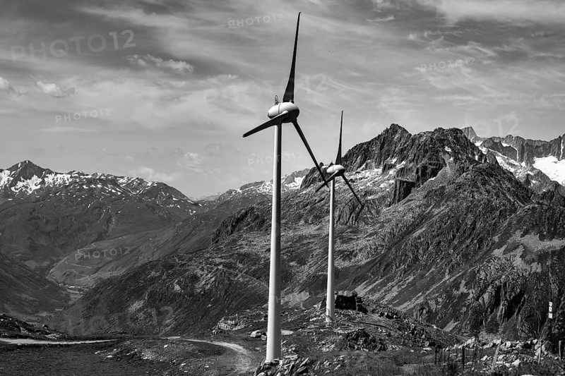 Wind Turbine and Mountain with Glacier and Against Sky and Clouds in a Sunny Summer Day in Andermatt, Uri, Switzerland