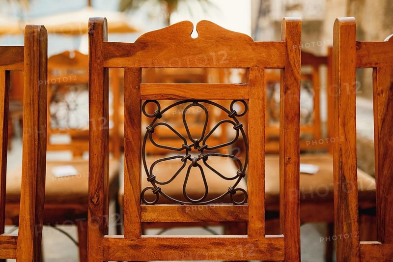 Forged pattern on the back of a wooden chair. Close-up.