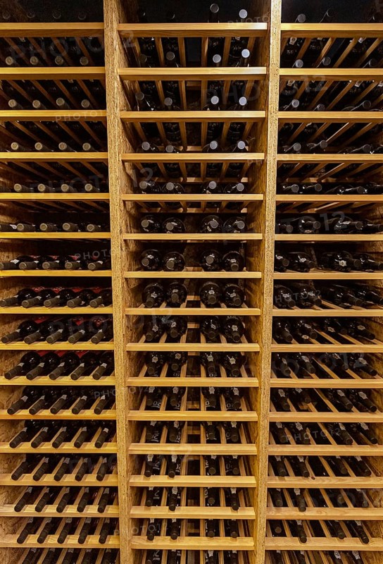Bottles with wine stacked on wooden racks