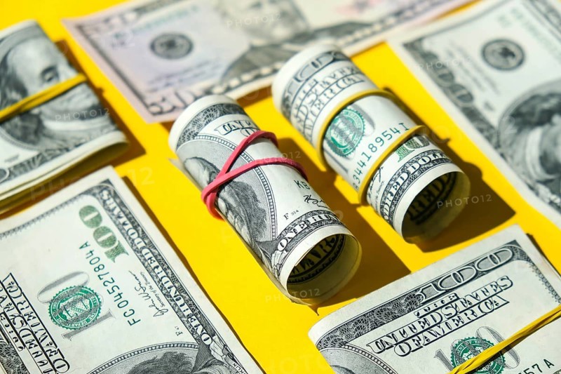 US dollars bundle close up isolated on dollar background. Paper denominations of dollars cash rolls with rubber bands. Business budget of wealth and prosperity finance. Pile capital of American US dollars bills notes cash