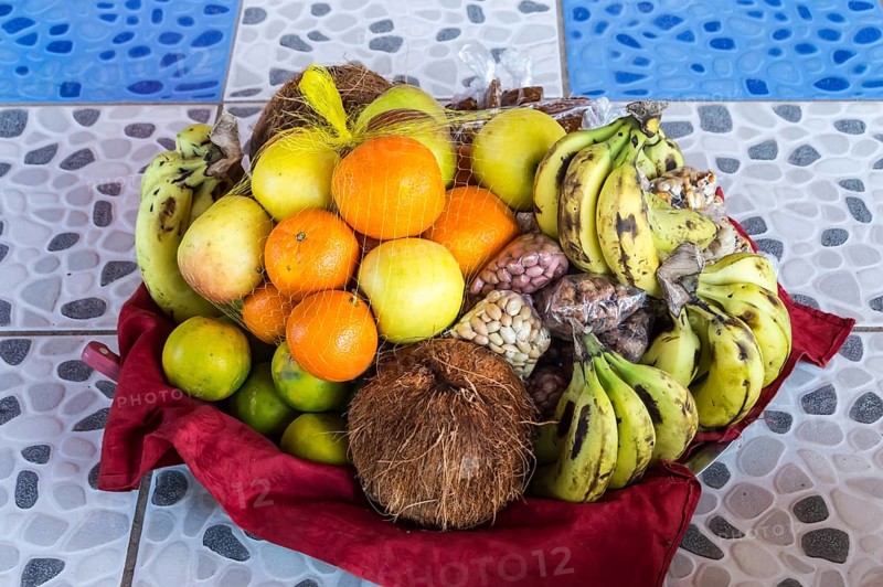 Colorful fresh fruits mixed in the basket lay on the tiling