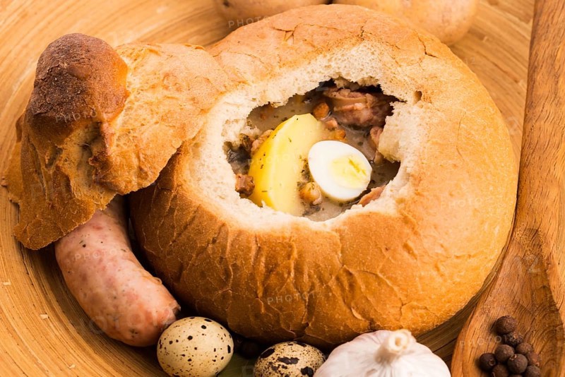 Traditional white borscht (zurek) with sausage, egg and mushrooms in bread as a dish