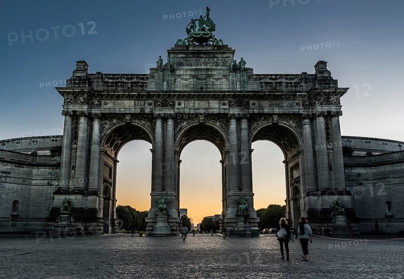 Brussels, Belgium, 06 26 2018: Tourists walking under the arcades of the Cinquentenaire monument at sunset