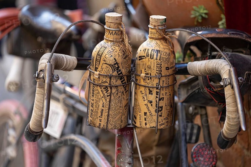 Two retro bottles attached to an old bicycle handlebar, at the legendary L'Eroica cycling race, Torrenieri, Tuscany, Italy