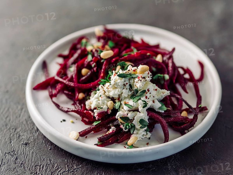 Raw beetroot spaghetti salad with soft cheese, nuts, thyme. Vegetable noodles - Fresh Beetroot Noodles with Ricotta and fresh thyme on plate. Copy space. Clean eating, raw vegetarian food concept
