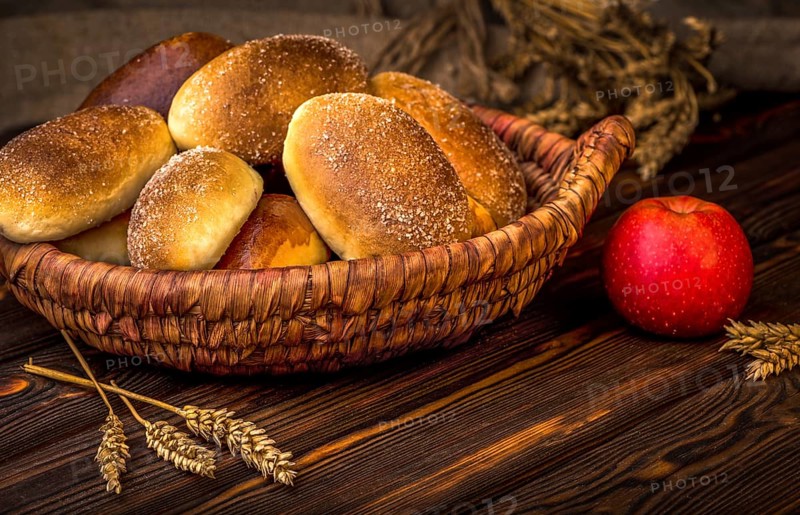 Ukrainian baked pies in wicker basket on wooden table