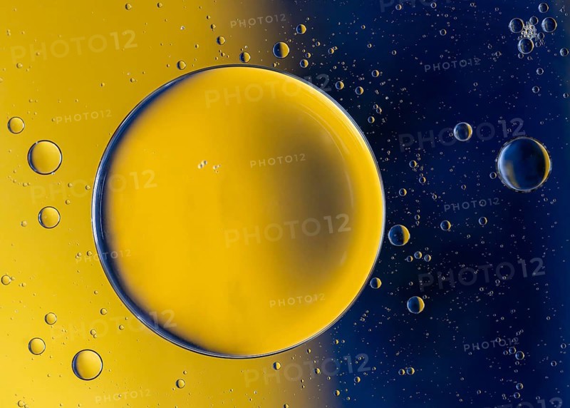 Abstract macro with oil drops in water, looking like planets in space