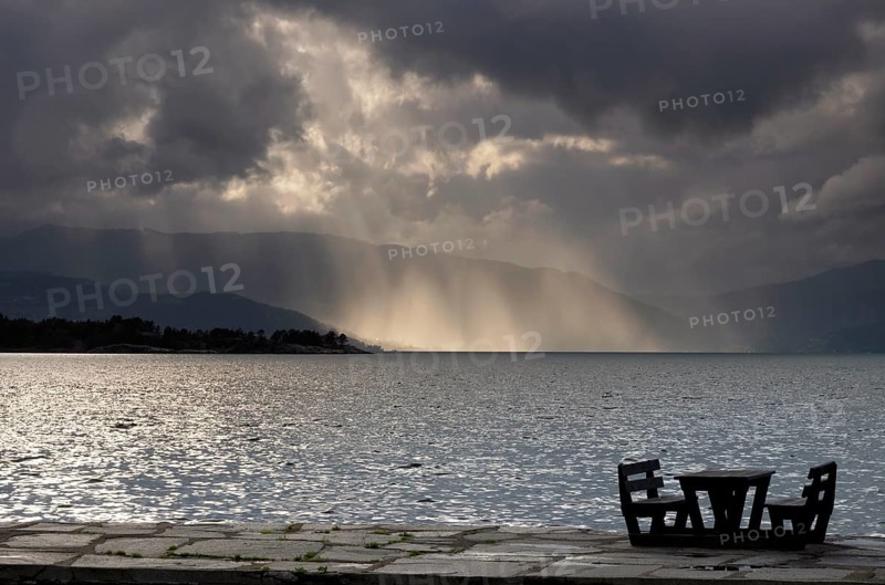 Empty picnic table in in the Norwegian village Herand in front of a dramatic sky over the Hardangerfjord