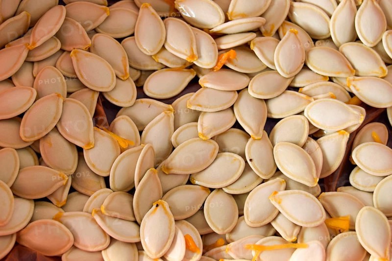 Close-up of raw pumpkin seeds, emphasizing their natural texture and fresh appearance