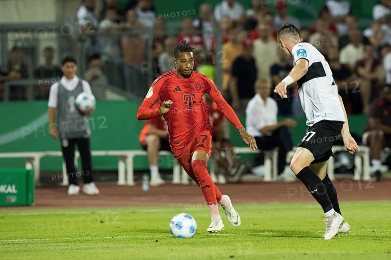 Football match, Michael Akpovie OLISE FC Bayern Munich left on the ball in a duel with Niklas KOLBE SSV Ulm, Donaustadion football stadium, Ulm, Germany