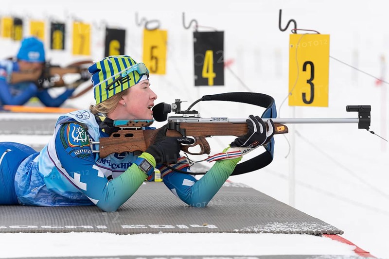 Sportswoman biathlete Legostaeva Anastasia rifle shooting in prone position. Biathlete in shooting range. Open regional junior biathlon competitions East Cup. Kamchatka, Russian Far East, Apr 12, 2019