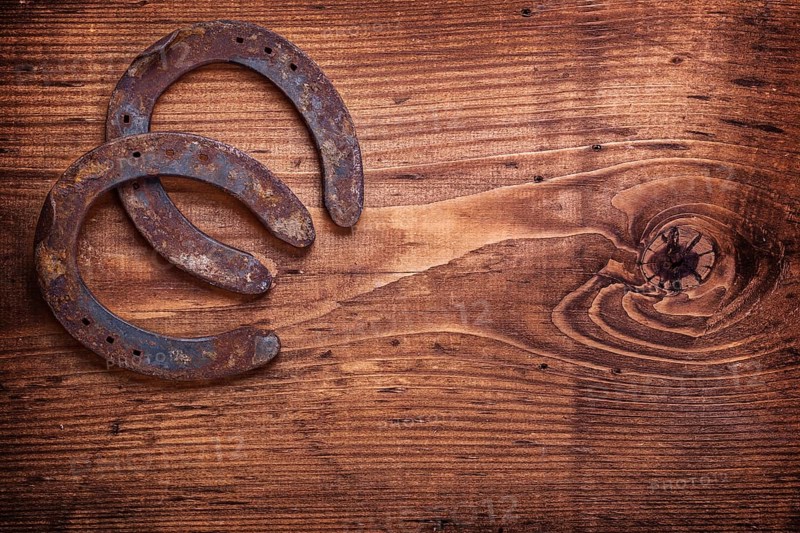 Two horseshoe on vintage wooden board close up happy concept