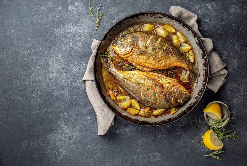 Food, Food, Baked sea bream or dorada with onion and herbs in pan on dark background