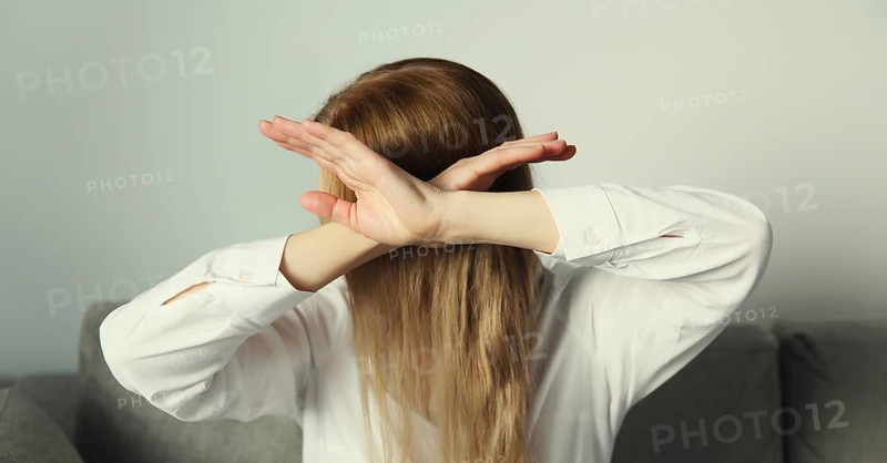 Close-up upset young woman shows stop, no or enough sign with palm of hand, refusal gesture, domestic violence