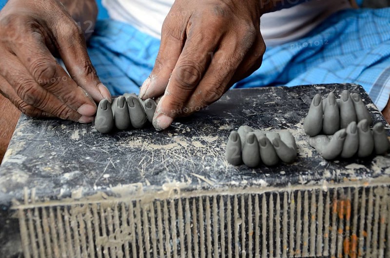 Man making fingers of clay, Kumartuli, Kolkata, West Bengal, India, Asia