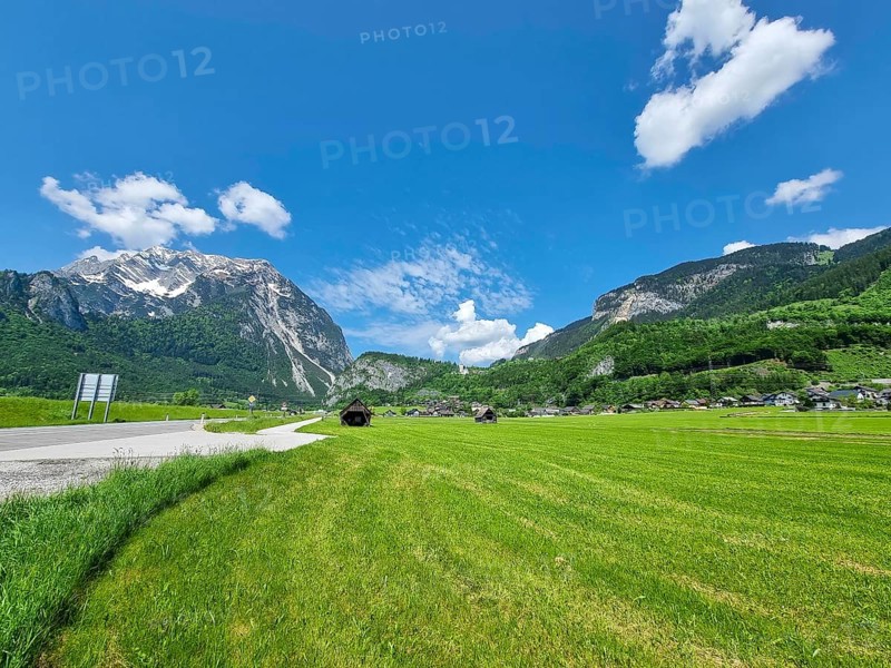 Summer austrian landscape with green meadows and Grimming mountain (2.351 m), an isolated peak in the Dachstein Mountains, in Styria region, Austria