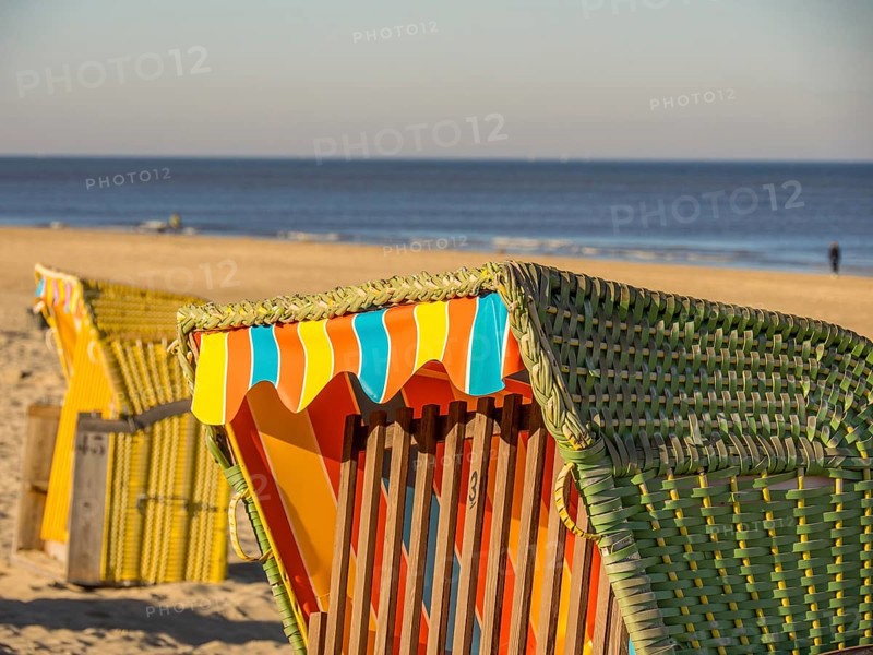 Close-up of a colourful beach chair on a sandy beach, overlooking the calm sea under a clear blue sky, egmond aan zee, the netherlands