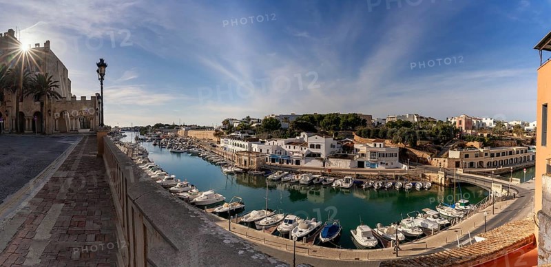 Ciutadella, Spain, 26 January, 2024: view of the Ciutadella town hall and the harbor and fisherman's district with a sunstar