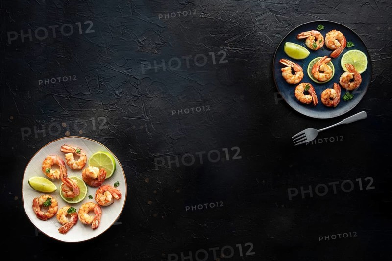 Shrimps, overhead flat lay banner with copy space. Cooked shrimp with lime, shot from the top on a black slate background with a place for text, Food photography, Food photography