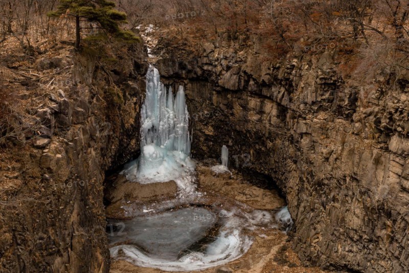 Looking down on frozen waterfall in deep crater located in Gyeonggi province of South Korea