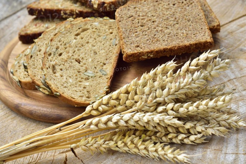 Cereal, wheat and bread on a wooden table. Different types of bread on wood