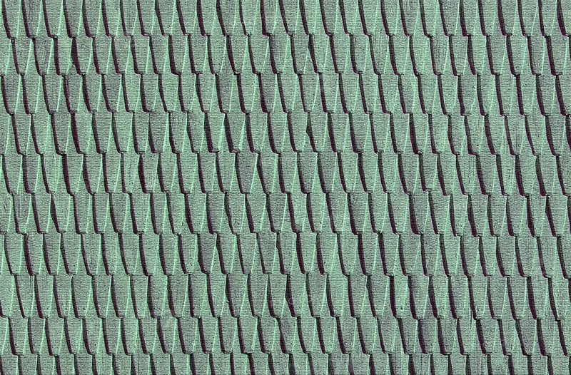 Green roof tiles create a uniform, textured pattern in a repetitive design.Belarus