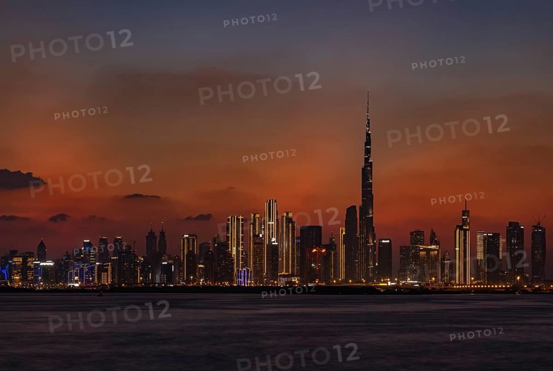 A colorful picture of Downtown Dubai at sunset, with the Burj Khalifa towering the other high rises