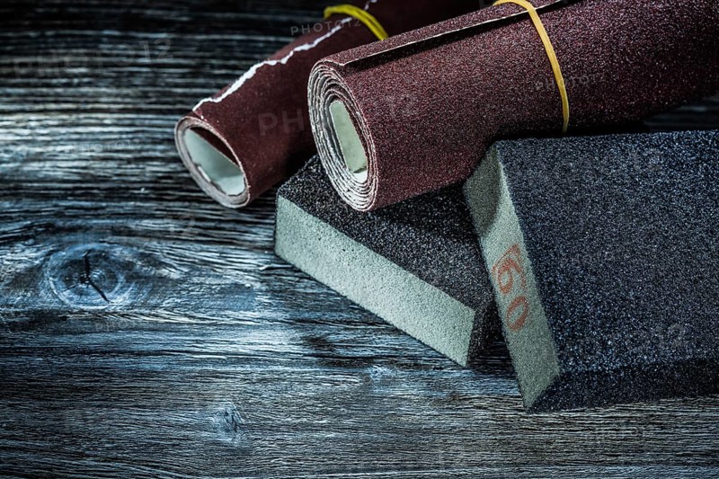 Rolled abrasive paper sponges on vintage wooden board