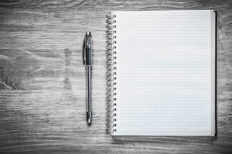 Squared copybook pen on wooden board education concept