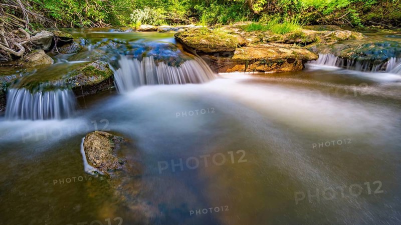 At the Felsenbad, a natural water pool with small waterfalls at lake Schussen in Upper Swabia