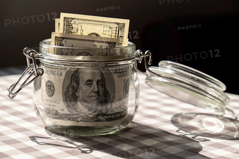 Dollar banknote saving money in glass jar. Consumption and economy Collecting money. Tips. Business, finance, saving, banking and people concept. Extra money, passive income. Saving for travel, crisis, house, car, education, retirement