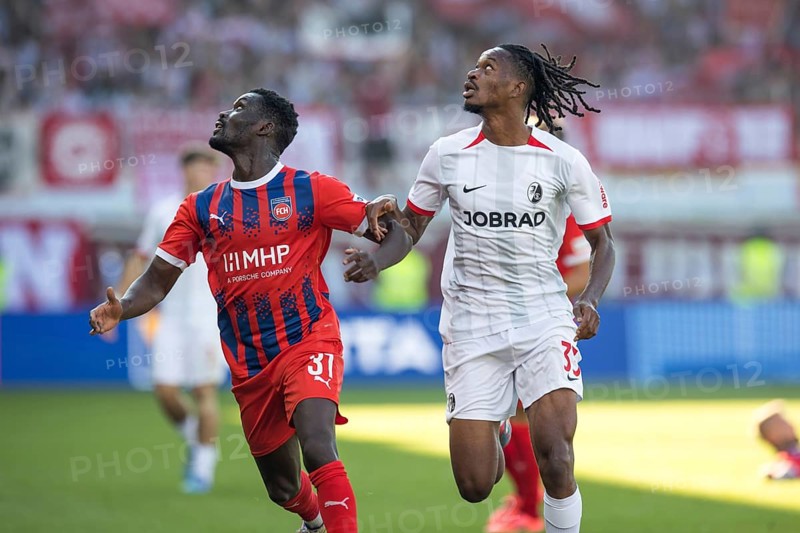 Football match, Sinlord CONTEH 1. FC Heidenheim left and Jordy MAKENGO SC Freiburg follow the ball looking to the left, football stadium Voith-Arena, Heidenheim