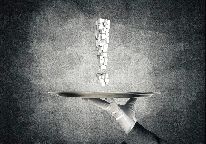 Cropped image of waitress's hand in white glove presenting multiple cubes in form of exclamation mark on metal tray