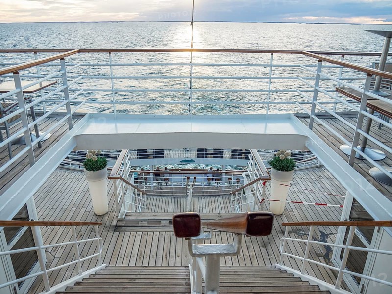 View of the deck of a ship at sunset with railings and a wooden staircase, svaneke, bornholm, baltic sea, denmark, scandinavia