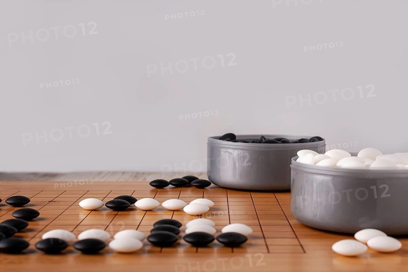 Wooden goban and dice for playing go, copy space, selective focus