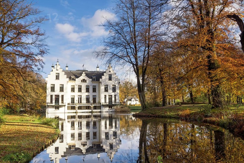 Castle Staverden reflecting in the moat and surrounded by autumn colored trees
