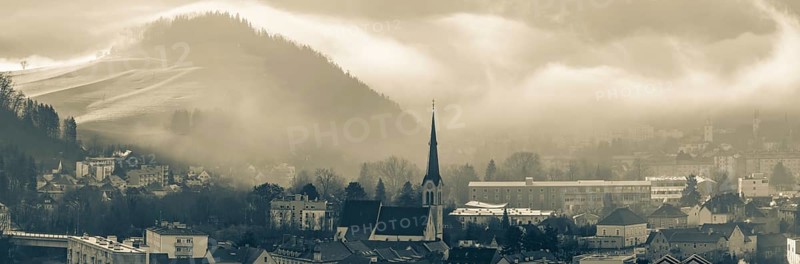 Morning atmosphere and morning fog over the Calvary, Waasenkirche church and old grammar school, Göss Abbey in the background, panoramic view, Leoben, Styria, Austria