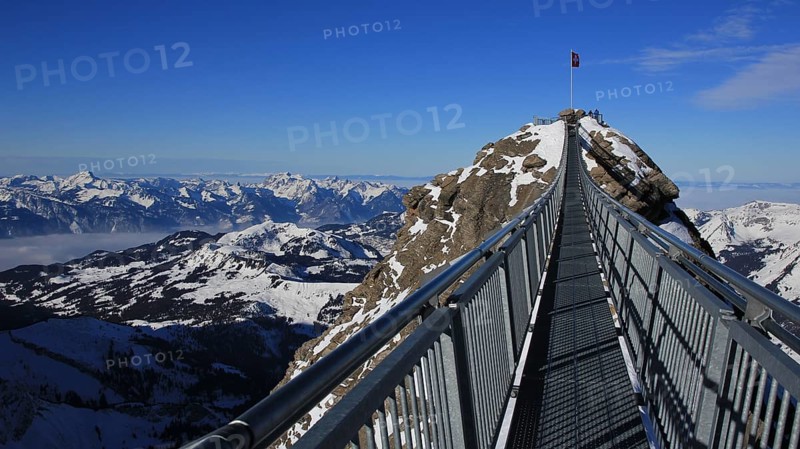 Winter scene in the Swiss Alps. Suspension bridge connecting two mountain peaks on 3000m altitude. View from the Glacier de Diablerets ski area