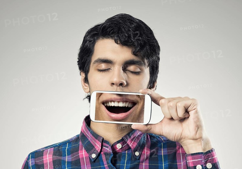 Young man holding smartphone with smile on screen