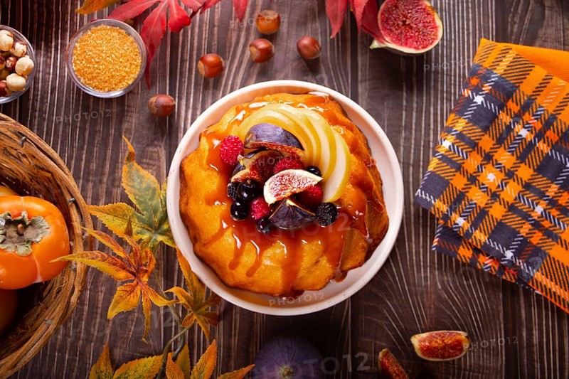 Delicious homemade autumn cake with figs and frozen berries for celebrating Thanksgiving day or Halloween. Top view