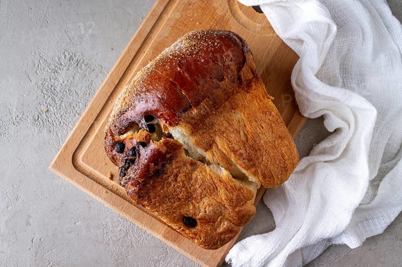 Wheat flour bread with raisins on a wooden board