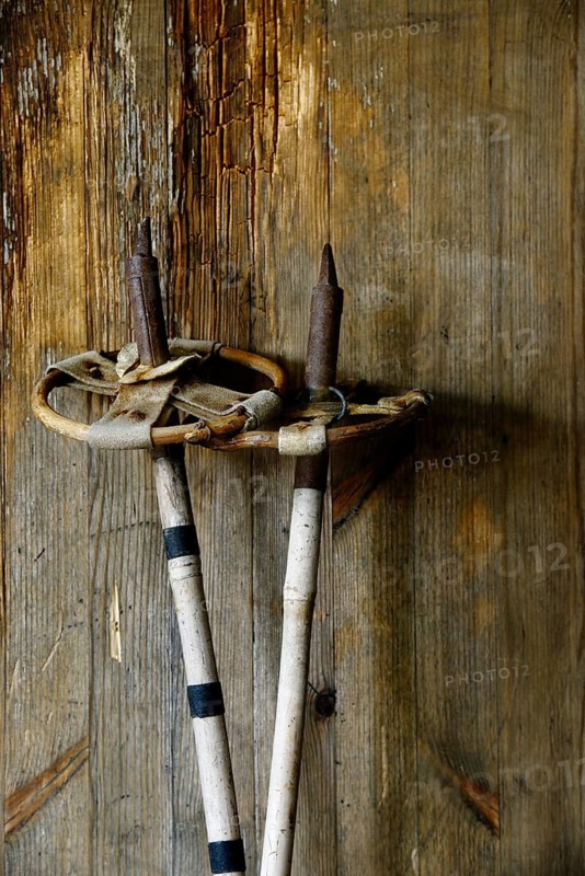 Old vintage ski poles on a wooden background