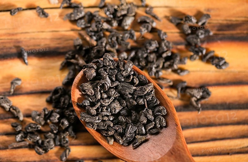 Dry puer tea leaf in wooden spoon on the rustick table